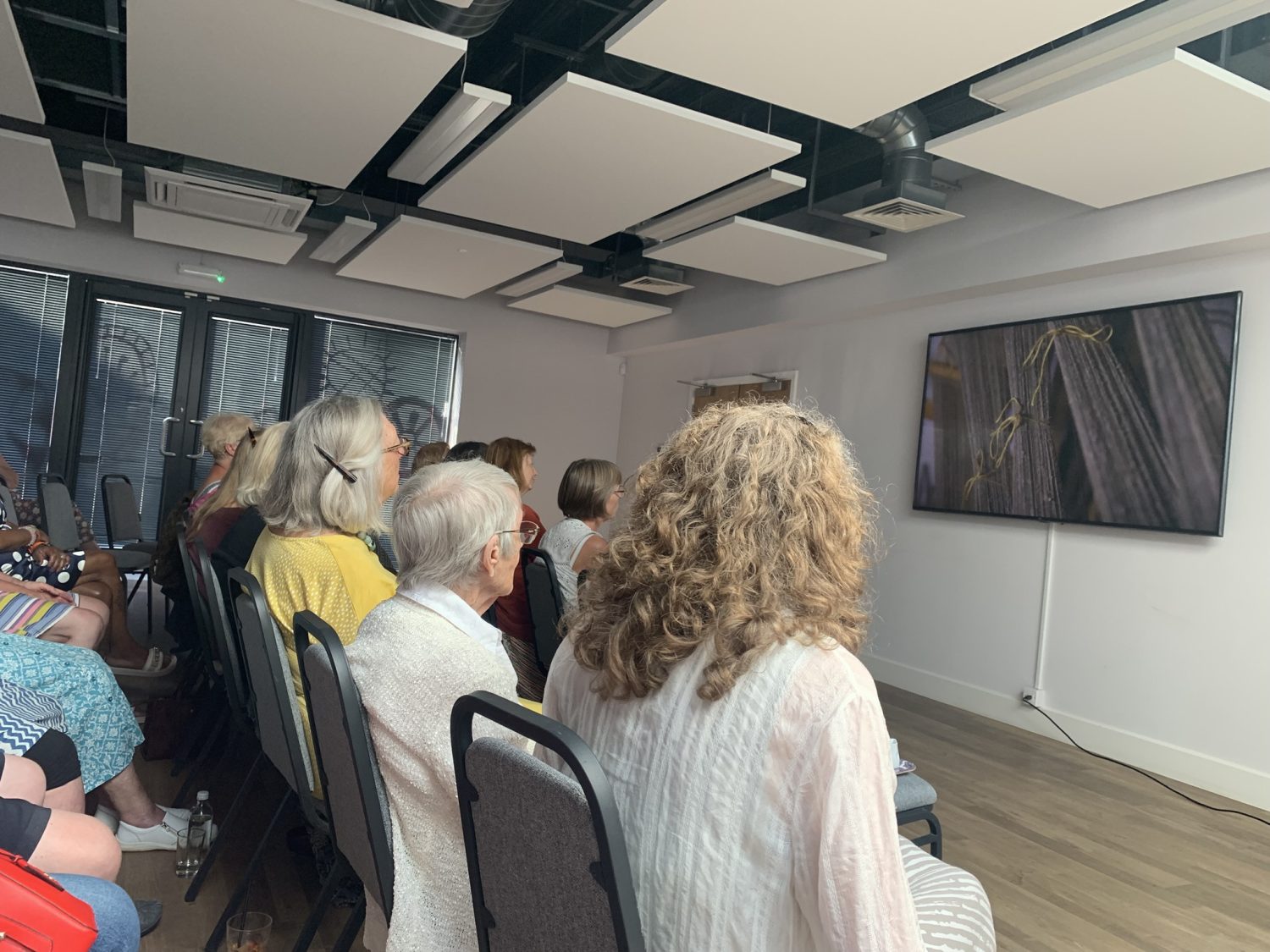people on chairs watching a large TV screen